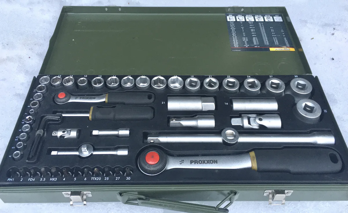 Sockets and two ratchets arranged in an open metal tool case on a white background.